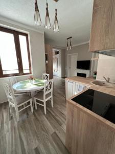 a kitchen and dining room with a table and chairs at Central House in Oradea