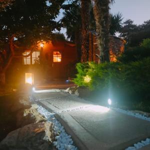 une maison la nuit avec des lumières dans l'allée dans l'établissement Chalet - Piscine - Wifi, à Penta-di-Casinca