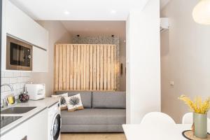 a living room with a couch in a kitchen at FLORIT FLATS - Urban Beach Rooms Valencia in Valencia