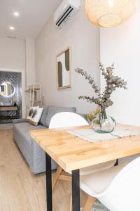 uma sala de estar com uma mesa e um sofá em FLORIT FLATS - Urban Beach Rooms Valencia em Valência