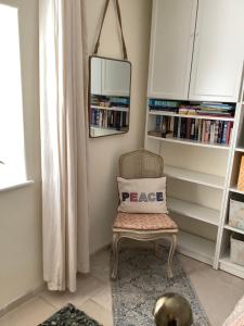 a room with a chair with a peace pillow on it at Garden apartment in Weston-super-Mare