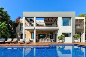 a house with a swimming pool in front of it at Lifestyle Villa Cap Martinet Ibiza in Talamanca