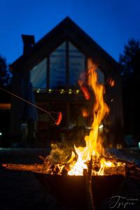 a fire pit in front of a house at night at Dziupla House in Czarna