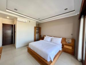 a bedroom with a large bed with white sheets at Sandat Living in Canggu