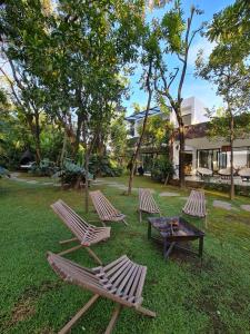 drie ligstoelen en een tafel in de tuin bij Casa Huitzil - La mejor casa de Malinalco con alberca y jacuzzi climatizados in Malinalco