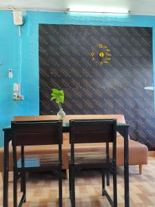 une table et deux chaises devant un mur dans l'établissement Nha Xanh Ha Long Homestay, à Hạ Long