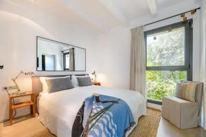 a bedroom with a large bed and a window at Lifestyle Villa Cap Martinet Ibiza in Talamanca +37 photos