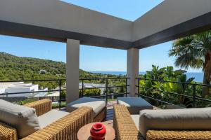 a balcony with couches and a view of the ocean at Lifestyle Villa Cap Martinet Ibiza in Talamanca
