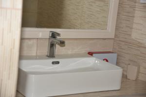 a white sink in a bathroom with a mirror at J&B Maisonette House in Marmari