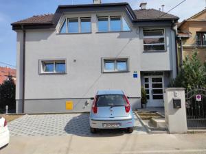 une petite voiture garée devant une maison dans l'établissement Apartments Battistutti Zagreb, à Zagreb