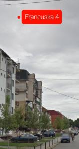 um sinal vermelho que lê francysska ao lado de um edifício em Square Apartment em Paraćin