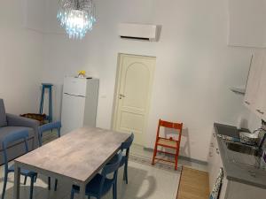 a kitchen with a table and a white refrigerator at InterMezzo - located in the center of Salento equidistant from the 2 seas in Scorrano