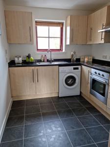 a kitchen with a sink and a washing machine at Superb 2 Bedroom Flat Tillicoultry in Tillicoultry