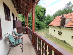 un balcone di una casa con due sedie sopra di House "Krasný Svet" - Holidayfarm Natural Slovakia a Modrý Kameň
