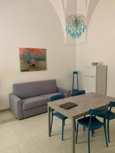 een woonkamer met een tafel en een bank bij InterMezzo - located in the center of Salento equidistant from the 2 seas in Scorrano