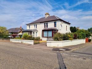 a white house on the side of a street at Inverness City 3 bedroom house in Inverness