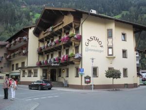 a building with flowers on the balconies on a street at Hotel Untermetzger in Zell am Ziller