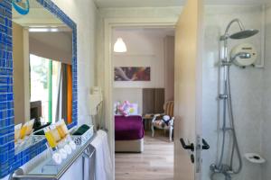 a bathroom with a shower and a sink with a mirror at Fitosinn Hotel in Paphos