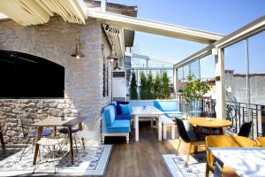 un patio con mesas y sillas y una pared de piedra. en Nowy Efendi Hotel - Special Category, en Estambul