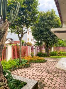 a stone walkway with trees and a fence at Hostel Wees een Kind in Malang