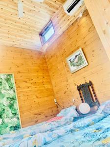 ein Schlafzimmer mit einem Bett in einer Holzwand in der Unterkunft ハセノ島　Hotel　Cottage in Kamakura
