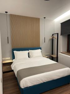 a bedroom with a large bed with a blue headboard at 11 Luxury apartments. in Metsovo