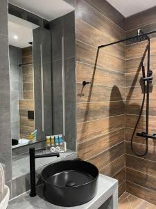 a bathroom with a black tub and a shower at 11 Luxury apartments. in Metsovo