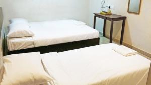 a room with two beds and a table with a mirror at Old Penang Hotel - Ampang Point in Ampang