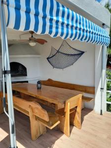 una mesa y un banco bajo una sombrilla en un patio en Villa Nora, en Pisak