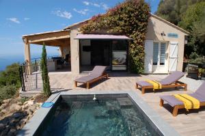 a swimming pool with two lounge chairs and a house at Villa CALANCA - Domaine La Raggia in Olmeto