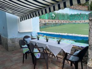 a table with chairs and a tennis court at Vistalegre78 in Grado