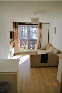salon z kanapą i dużym oknem w obiekcie La Foux d'Allos STUDIO 4 PERSONNES 23m2 résidence les Etoiles w mieście Allos