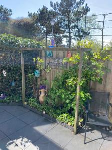 un jardín con una valla de madera y un jarrón en Dutch Line, De Schelp, Gratis parkeren, en Zandvoort