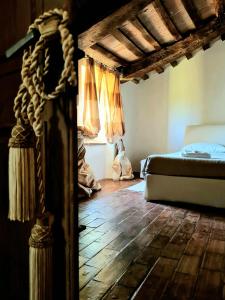 1 dormitorio con 1 cama y suelo de madera en dalla fortezza al mare - la vostra casa a San Leo en San Leo