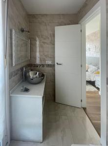 ein Badezimmer mit einem Waschbecken, einem Spiegel und einer Tür in der Unterkunft Vistalegre78 in Grado