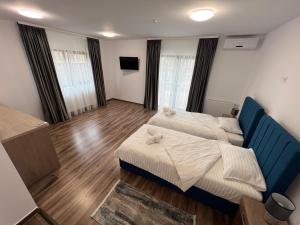a bedroom with two beds and a blue couch at Aparthotel Plevnei4 in Cluj-Napoca
