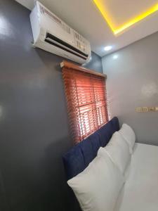 a room with a blue couch and a heater and a window at Wine House, Maitama, Abuja in Abuja