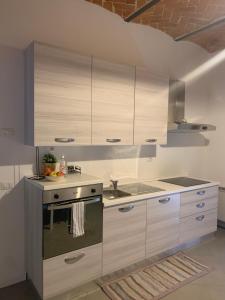 a kitchen with white cabinets and a sink and a stove at I Platani 2 in Montecatini Terme