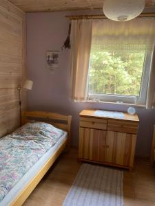 a bedroom with a bed and a window at Mazurskidom Zapiecek in Świętajno