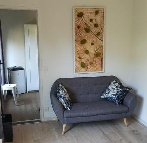 - un canapé dans le salon orné d'une peinture murale dans l'établissement Le Merle Rose, à Toulouse