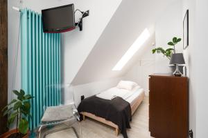 a bedroom with a bed and a tv and a chair at Apartament "Holy" in Poznań