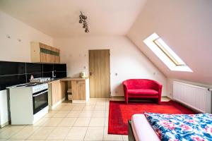 a kitchen with a red chair in a room at Apartmán u lesa in Klobouky u Brna