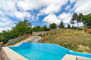 a blue swimming pool on a hill with stairs at Apartmán u lesa in Klobouky u Brna