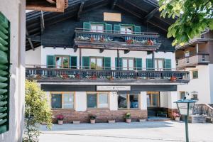 ein großes Gebäude mit Balkonen und Blumen darauf in der Unterkunft Kaiser Apartments in Scheffau am Wilden Kaiser