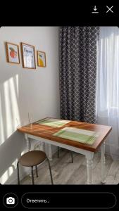 Квартира посуточно في أورالسك: طاولة طعام مع كرسي ونافذة