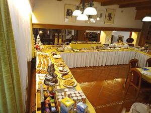 una línea de buffet con comida en una mesa larga en Park Hotel Arnica, en Falcade