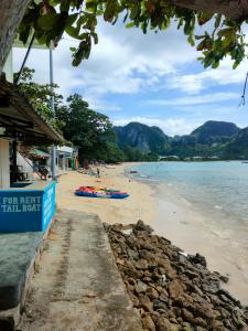 a beach with a boat in the water at Dalum Beachhouse in Phi Phi Islands