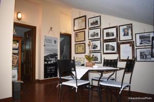 een eetkamer met een tafel en stoelen en foto's aan de muur bij Bed & Breakfast La Costa in Cassino