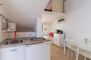 een keuken met witte kasten, een wastafel en een tafel bij Villa Algi in Nardò