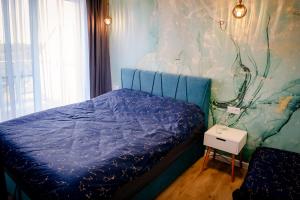 sypialnia z łóżkiem z niebieską kołdrą w obiekcie Apartamenty Białe Tomasza 4 w mieście Augustów